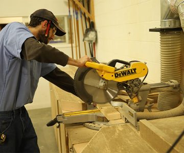 image of student using table saw to cut a piece of wood