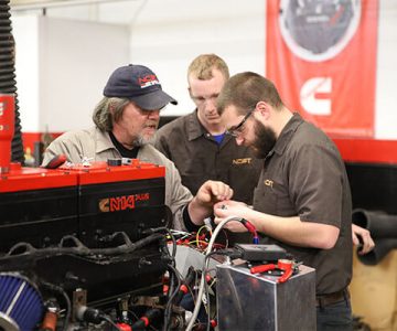 image of students in lab learning the wiring and hoses of a cummins diesel engine