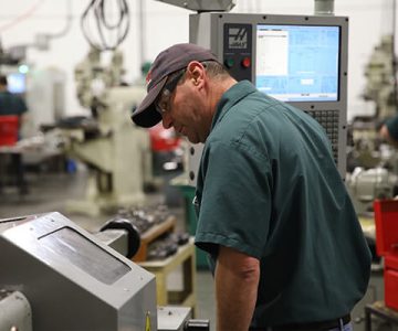 image of instructor monitoring CNC machine computer