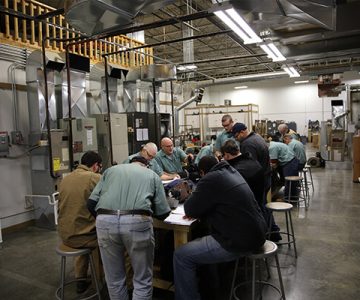 image of a group of students working at a table in a factory