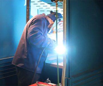 Image of student in welding booth, working on welding project