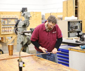 image of student cutting copper pipe