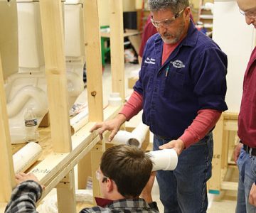 image of students working on broken toilet with the help of an instructor