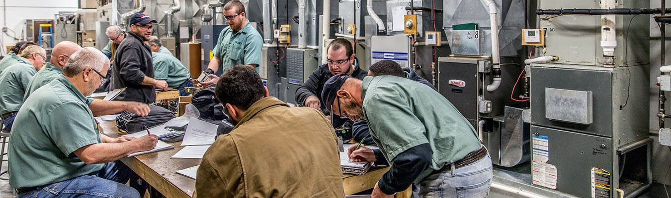 image of students working at table inside the HVAC lab at the New Castle Campus