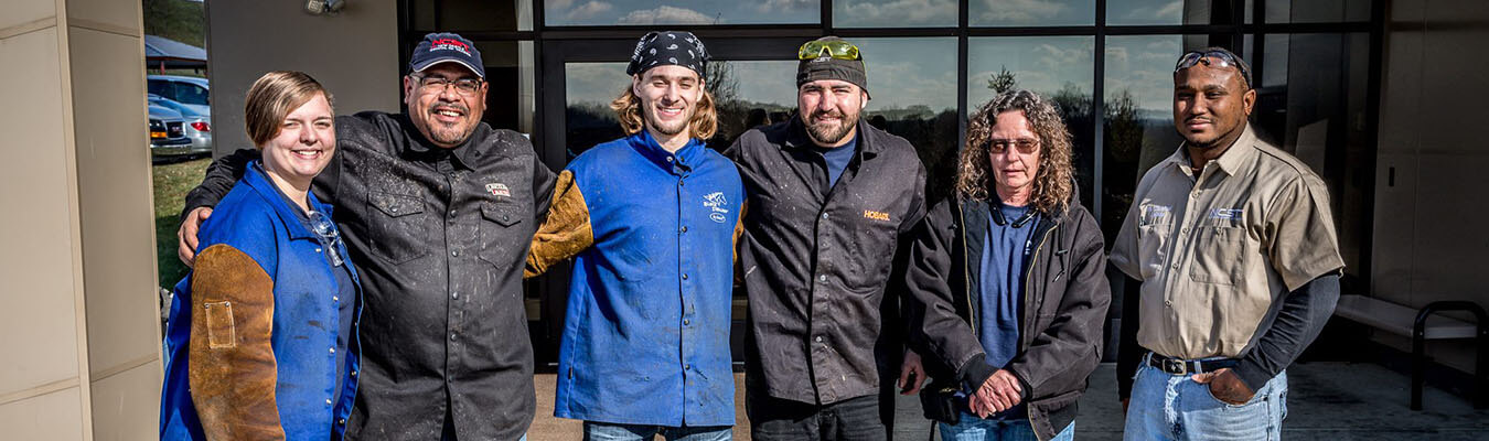 Image of NCST students and staff lined up together smiling while in uniforms