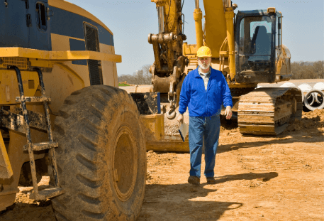 Image of Heavy Equipment With Operator walking next to it