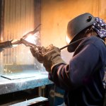 image of a welder working in a lab with spark flying.