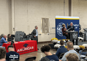 Members of NCST and America's Trades Foundation standing near podium on stage