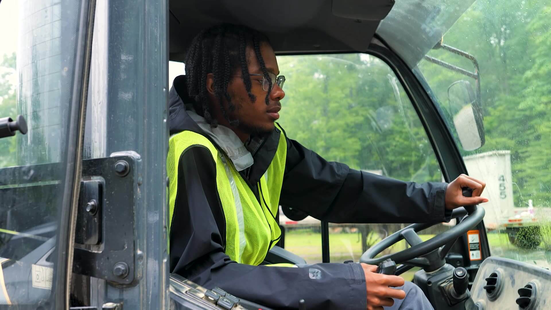 Orion driving a bulldozer, closeup shot of inside the heavy equipment cab