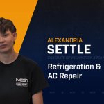 Alexandria Settle standing with arms crossed with NCST themed backdrop