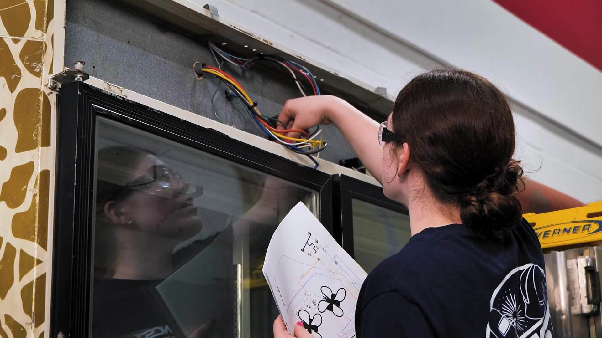 Emily working on the top of a HVAC system