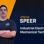 Josh Speer standing with arms crossed with NCST themed backdrop