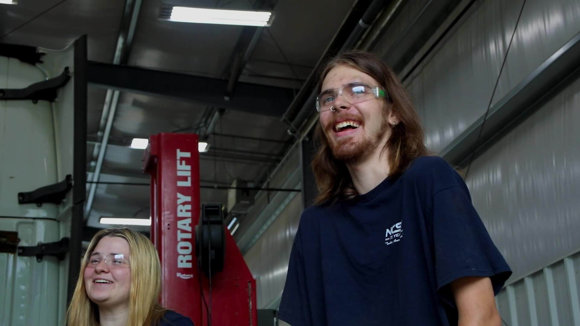 Alex Gill smiling with another student in workshop