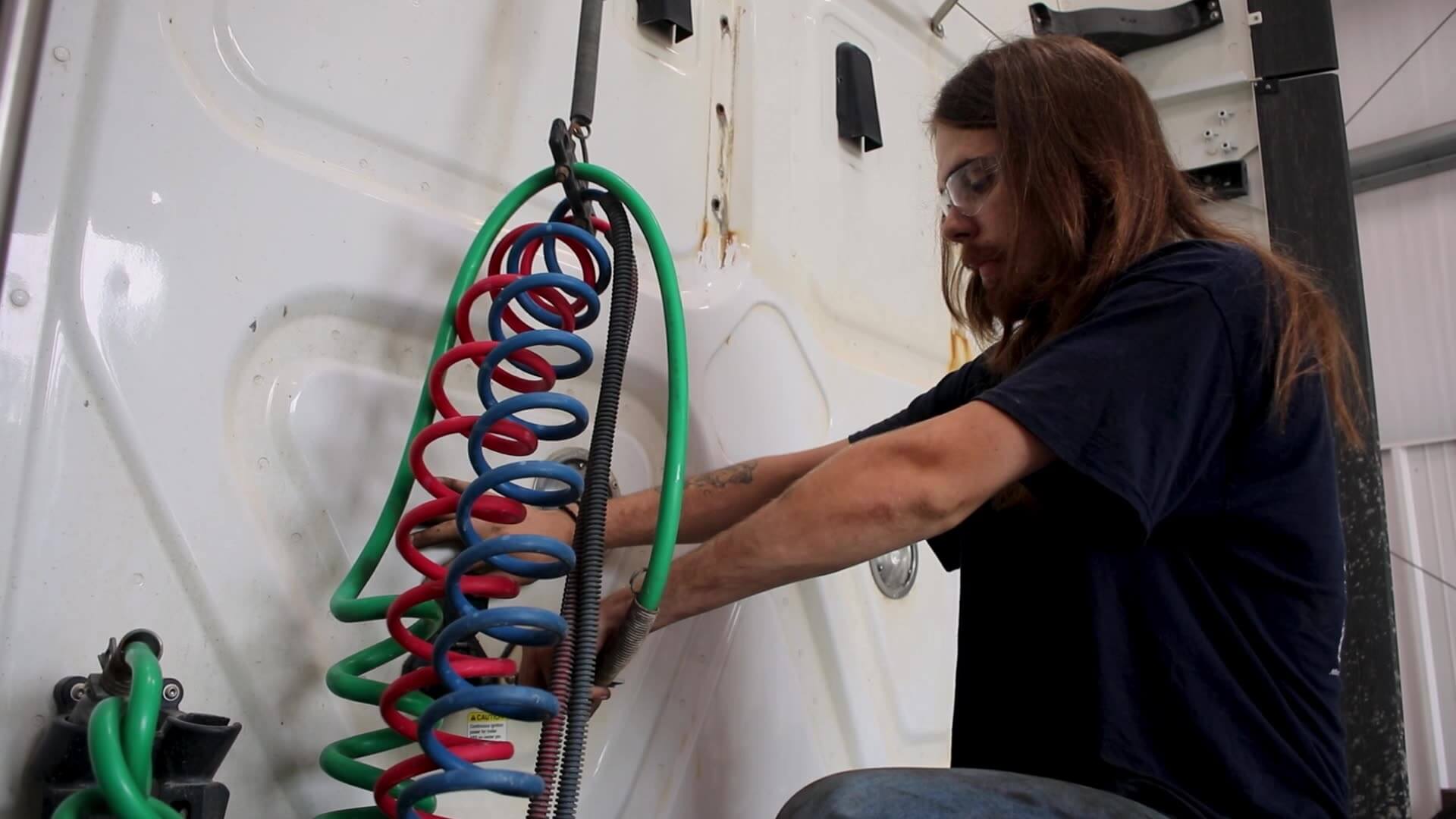 Alex Gill working on airlines of a semi truck