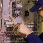 Electrical Technician student working on a wall of circuits