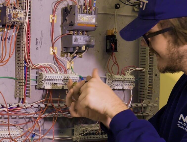 Electrical Technician student working on a wall of circuits