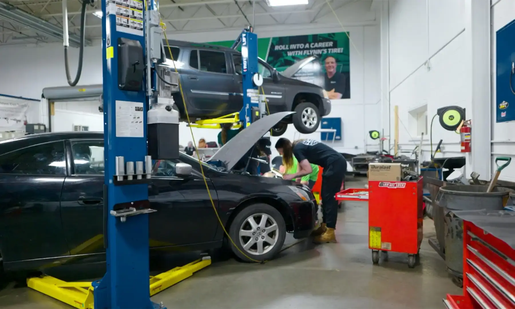 Student looking in hood of car in an Automotive Technology lab