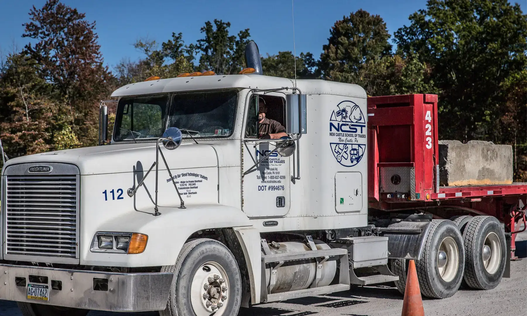 Closeup of NCST semi truck with a driver in the driver seat