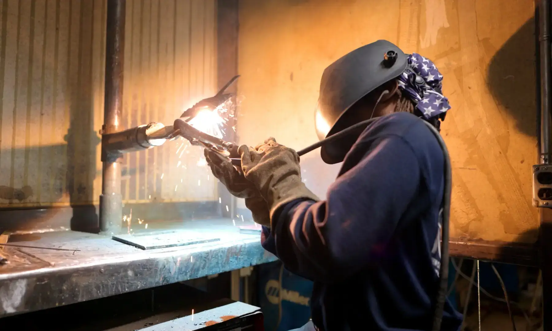 Student welder welding metal