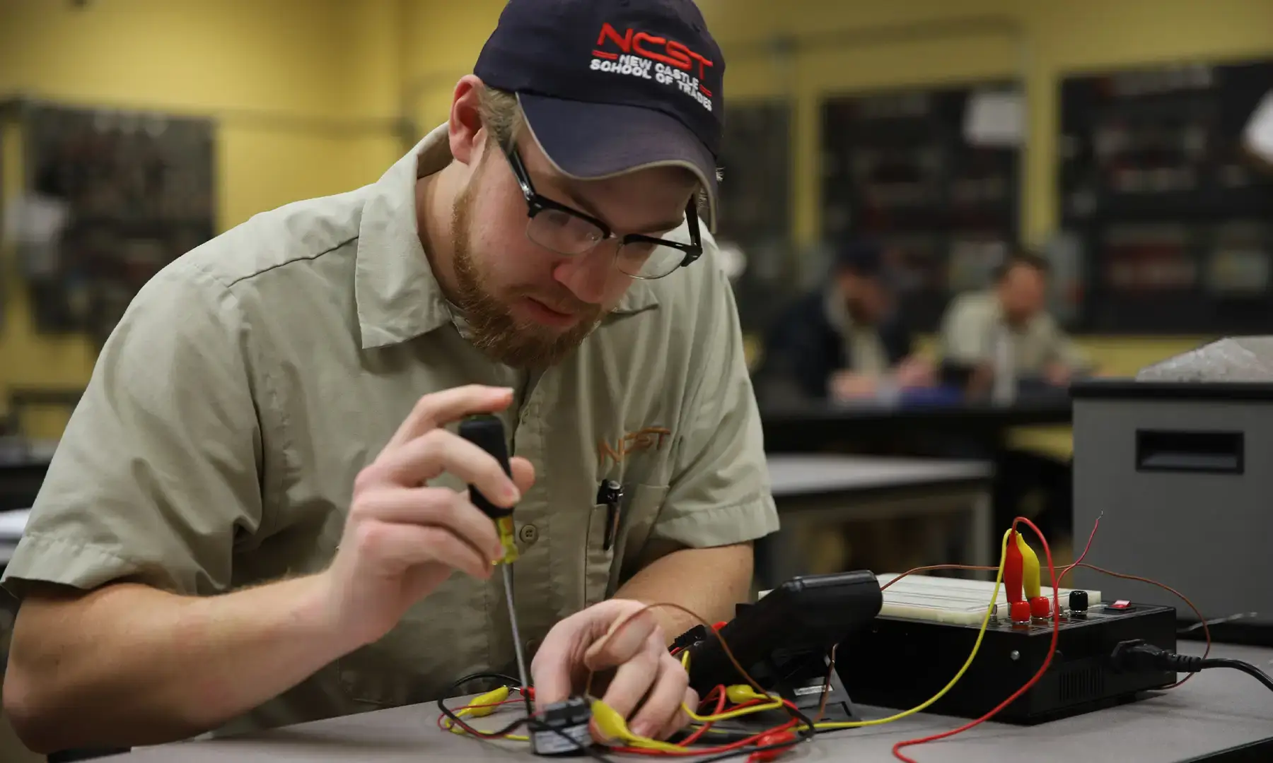 Electrical Technology student working with wires and circuit panel