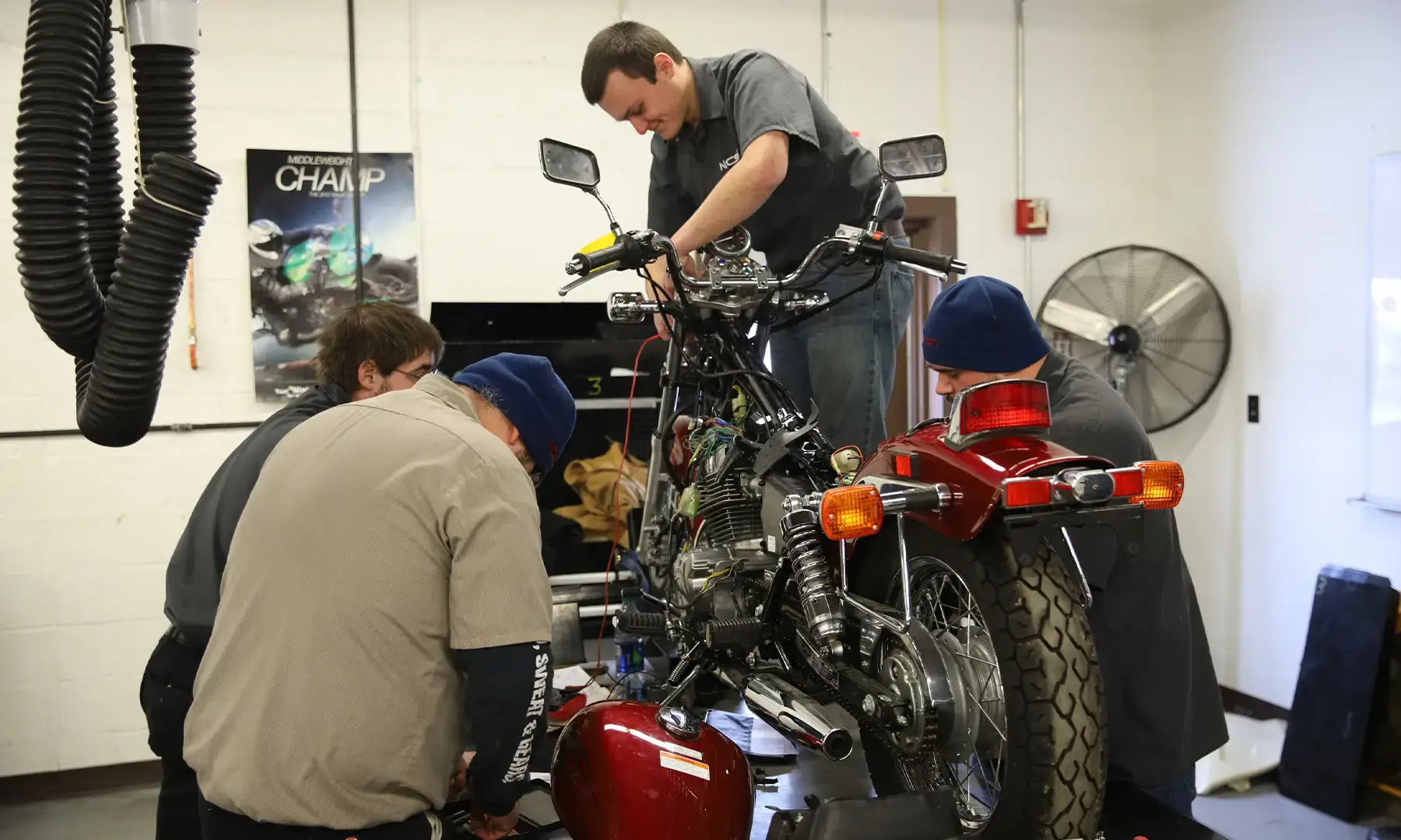 Group of Motorcycle Equipment Technology students working on a motorcycle