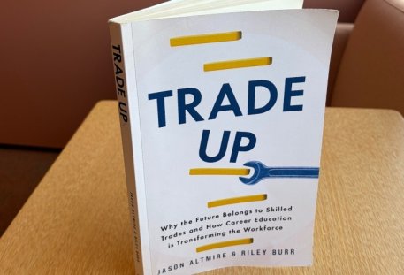 "Trade Up" book standing up on a desk