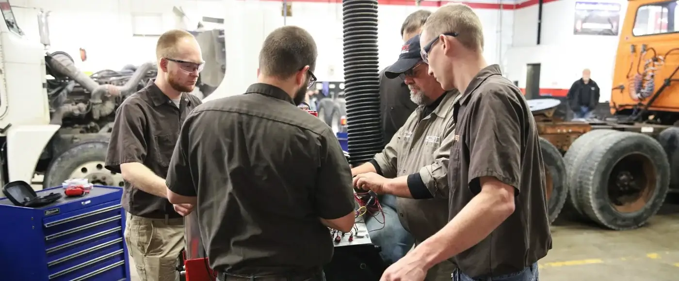 Students working on a truck engine together
