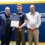 NCST staff and scholarship recipient hold scholarship together