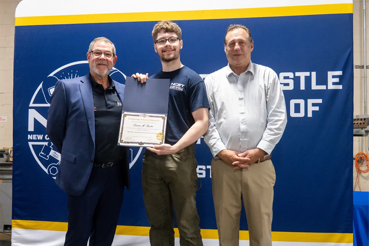 NCST staff and scholarship recipient hold scholarship together